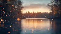 Tranquil lake at sunset with glowing bokeh lights floating in foreground, silhouetted pine forest reflecting on calm water surface creates dreamy atmosphere.
