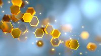 Golden hexagonal shapes floating in soft blue atmosphere with glowing particles and bokeh effects create abstract technological or scientific background.