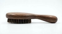Vintage wooden brush with natural bristles and worn handle, suitable for cleaning, grooming, or craft projects.