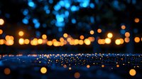 Glowing golden bokeh lights creating magical atmosphere against dark blue background with water reflections, perfect for festive and romantic designs.