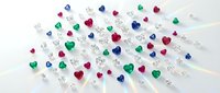Colorful heart-shaped gemstones and diamonds scattered on white surface for jewelry design, Valentine's Day decorations, and romantic crafts.