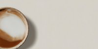 Creamy latte with heart-shaped foam art in ceramic cup on neutral beige background, top view flat lay composition for cafe branding and coffee shop marketing.