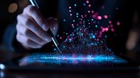 Magical splash of blue and pink glowing particles bursting upward from digital tablet surface as artist hand draws with stylus pen in dark atmosphere.