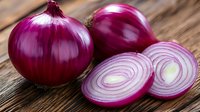 Fresh red onion whole bulbs and sliced rings on rustic wooden background, vibrant purple color and detailed texture for cooking and food photography.