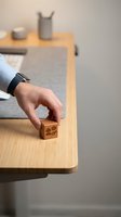 Businessman hand placing wooden cube with contact icons on modern office desk for customer service and communication concept.
