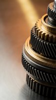 Close-up of precision automotive transmission gears with golden lighting showcasing mechanical engineering and industrial manufacturing components.