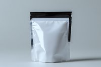 White blank stand up pouch with black zipper closure on gray background, mockup for product packaging design and branding presentation.