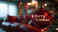 Red glass ball ornament with Merry Christmas text hanging on tree branch, bokeh lights and cozy interior atmosphere in soft focus background.