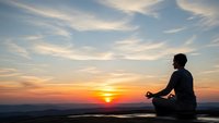 Young man meditating in lotus position during golden hour sunset with dramatic sky and peaceful landscape view for wellness and mindfulness concepts.