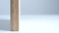Minimalist wooden plywood board with natural grain texture standing vertically against clean white background for modern interior design projects.