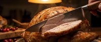 Carving knife slicing into golden roasted meat with crispy skin, perfect for culinary, food preparation, and restaurant content.