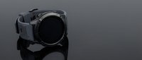 Modern black smartwatch with digital display and silicone strap on reflective surface for technology and wearable device concepts.