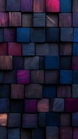 Abstract geometric background with textured wooden cubes in dark blue, purple, and pink tones creating dimensional pattern with dramatic lighting effects.