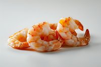 Fresh cooked shrimp tails on white background, close up view of pink prawns arranged in row, seafood culinary concept for restaurant menu and cooking.