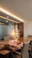 Businessman hands holding glowing torch symbol in modern office boardroom representing leadership innovation and entrepreneurial spirit in corporate environment.