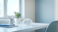 Modern minimalist workspace with white desk, decorative brain model, potted plant, and office supplies in bright natural light for productivity concepts.