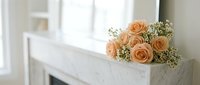 Elegant peach roses bouquet with baby's breath on white wooden mantel in bright interior room for romantic home decor and wedding inspiration.