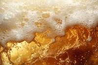 Macro shot of beer foam and bubbles with amber liquid beneath creating abstract golden patterns and textures. Refreshing carbonated beverage background.