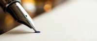 Elegant fountain pen with gold nib writing on cream paper with warm bokeh lighting creating professional business atmosphere for contracts and documents.