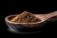 Ground cinnamon powder in wooden spoon against black background, dramatic lighting highlights aromatic spice texture and natural brown color.