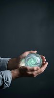 Male hands holding glowing green energy sphere with swirling light effects against dark background for technology and innovation concepts.