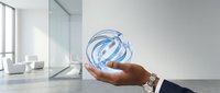 Businessman hand holding glowing blue globe sphere with swirl lines in modern office space, representing global business, technology, and digital connectivity for corporate solutions.