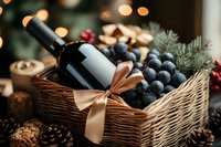 Wine bottle with golden bow in wicker basket alongside fresh grapes, pine cones and festive holiday decorations against blurred bokeh lights background.