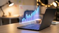 Business analytics hologram displaying growth chart above laptop computer on wooden desk in modern office workspace with warm lighting.
