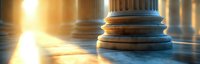Dramatic marble columns in golden sunlight create architectural backdrop with classical pillars casting long shadows on stone floor. Panoramic view.