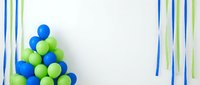 Blue and green balloons arranged in corner with colorful streamers on white background for party decorations and celebrations.