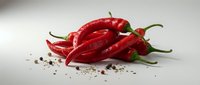 Fresh red chili peppers with scattered seeds on white background, suitable for food, cooking, and culinary design projects.
