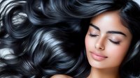 Young woman with flowing black hair spread on dark background, eyes closed with serene expression showing healthy, shiny, long wavy hairstyle. Suitable for beauty and haircare advertising.