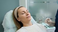 Young Caucasian woman receiving professional facial injection treatment at modern medical spa clinic for anti-aging skincare and cosmetic enhancement procedure.
