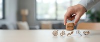 Business professional selecting wooden block with leads text from row of marketing icons on desk in modern office environment for sales strategy.