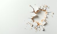 Broken hole in white wall with cracked plaster and debris, creating dramatic impact effect on light background. Useful for construction or renovation concepts.