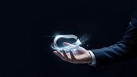 Virtual reality headset glowing in businessman's hand against dark background, representing future technology, digital innovation, and metaverse development for business solutions.