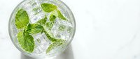 Refreshing mint mojito cocktail with fresh green leaves and ice cubes in glass, top view on white background for summer drink menu design.
