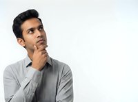 Young man with dark hair and South Asian ethnicity wearing gray casual shirt, hand on chin in thoughtful pose against white background, suitable for business, education, and lifestyle concepts.