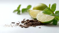 Fresh lime slices with mint leaves and chocolate shavings on white background, creating contrast for cocktail garnish or dessert decoration.
