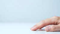 Hand reaching forward on clean white surface with soft lighting for business and technology concepts.