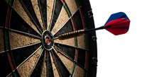 Dart hitting bullseye on dartboard showing precision, accuracy and success in competitive sports and target achievement games.