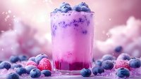 Purple berry smoothie with fresh blueberries and raspberries in glass on pink background. Healthy breakfast drink with antioxidants for wellness lifestyle.