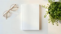 Minimalist white blank notebook with clean pages next to gold-rimmed glasses and green plant on neutral background for branding mockup design.