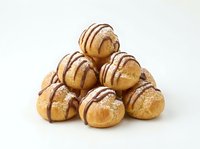 Profiteroles stacked in pyramid formation with chocolate drizzle and powdered sugar on white background, isolated for bakery, dessert, and food design projects.