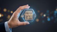 Businessman hand holding glowing hexagonal icon with storefront symbol, representing digital retail, e-commerce platform, online shopping business solution.