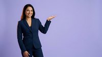 Professional businesswoman in navy suit presenting with open palm gesture on purple background for corporate marketing materials.