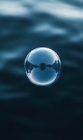 Soap bubble floating against dark blue ocean water background with silhouette of swimmer inside, capturing moment of fragility and freedom for editorial and conceptual projects.