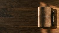 Vintage leather journal with pen on wooden surface, top view for stationery and office design projects.