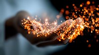 Magical glowing orange sparkles and light particles flowing from cupped hands against dark background, creating mystical ethereal effect for fantasy designs.