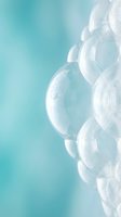 Transparent soap bubbles floating against soft turquoise gradient background creating dreamy ethereal atmosphere for wellness and relaxation concepts.